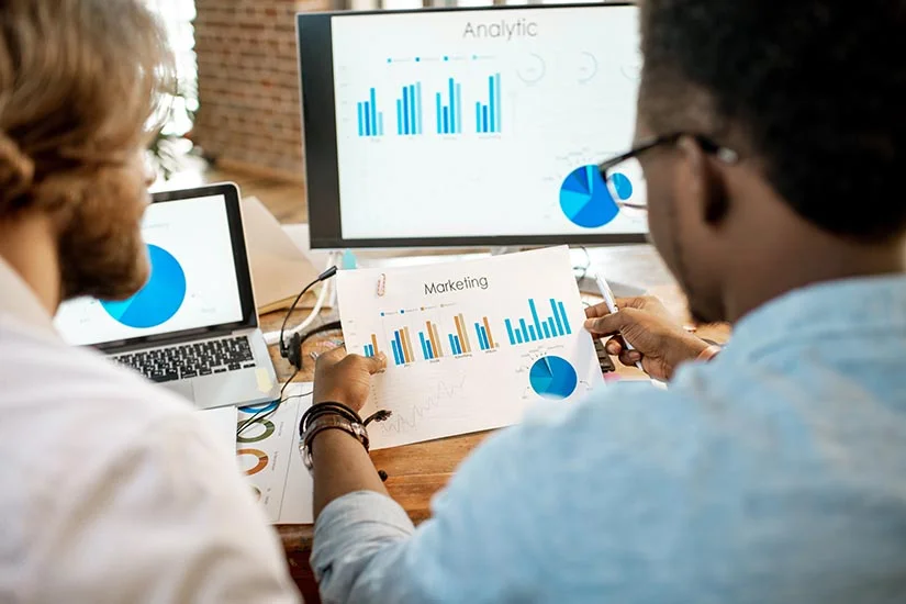 Pessoas analisando dados com tecnologia e dashboards