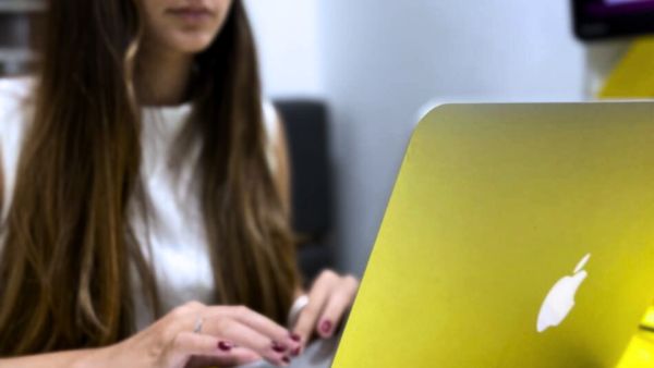 Mulher digitando no computador sobre conteúdos