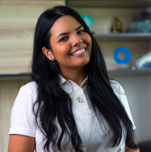 Mulher sorrindo de cabelos pretos usando branco
